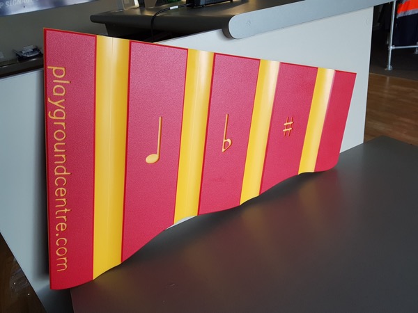 Routed and painted playgroundcentre.com sign with musical note motifs