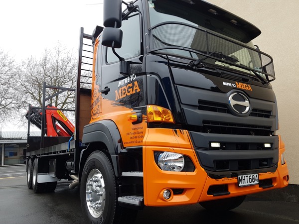 Hino flat-deck crane truck signwritten for Mitre 10 Mega Whanganui